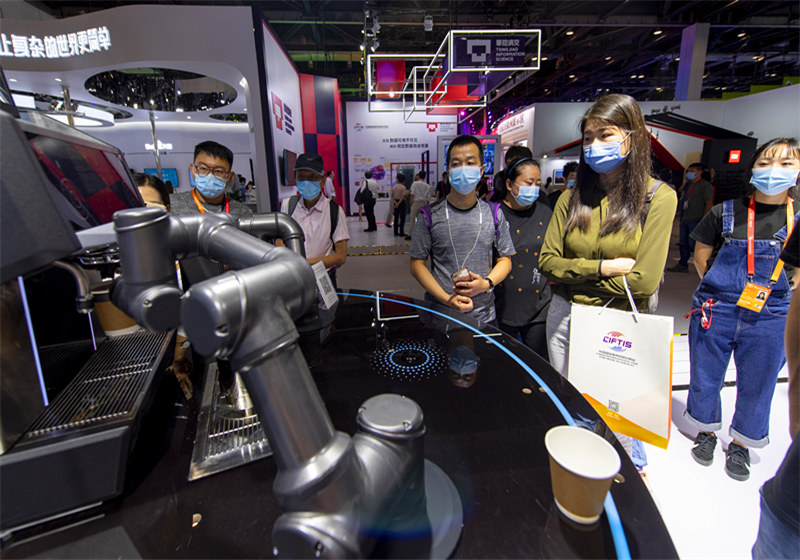 9月5日，在服貿會綜合展區的高通展台，參觀者正在體驗咖啡機器人。（人民網記者 翁奇羽 攝）
